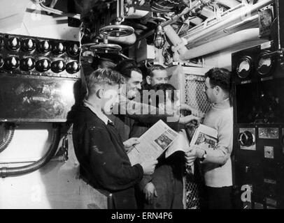 Sous-mariniers, la lecture de la photo du Daily Mirror bon journal du matin, qui a été spécialement édité et distribué pour la Royal Navy Marine Corps pendant la Seconde Guerre mondiale. Sur la photo 26 septembre 1945. Le HMS tacticien, construit comme P314 par Vickers Armstrongs, Barrow, et lancé le 29 juillet 1942. Banque D'Images