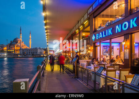 Restaurants en plein air sous le pont de Galata avec Yeni Cami ou nouvelle mosquée dans l'arrière-plan au crépuscule, Istanbul, Turquie Banque D'Images