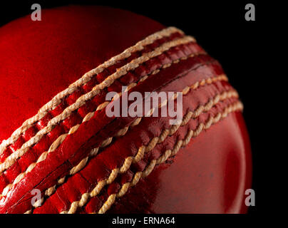 Cricket Ball en cuir rouge sur noir Banque D'Images