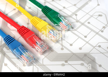 Quatre câbles réseau multicolores. Rouge, Jaune, Vert, Bleu. Les câbles sont situées partout sur le dessus de la carte de circuits imprimés blanc Banque D'Images