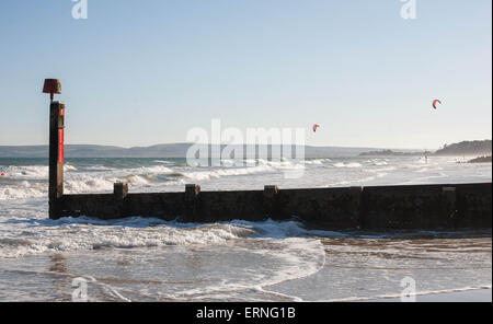 Kite surfeurs profitant des vents violents sur la plage de Bournemouth Banque D'Images