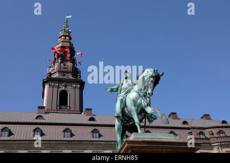 Copenhague, Danemark, 5 juin 2015. La modification de la Constitution danoise en 1915 a donné aux femmes danoises le droit de vote et de se présenter aux élections. Cet important anniversaire est célébré à Copenhague, le jour de la Constitution, par le Gouvernement, le Parlement et le festival de distorsion qui se tient actuellement à Copenhague. Les événements sont concentrés autour du Palais Christiansborg. La statue équestre du roi Frederik 7ème en face de Christiansborg présentant les drapeaux danois dans les tourelles de la tour. Crédit : Niels Quist/Alay Live News Banque D'Images