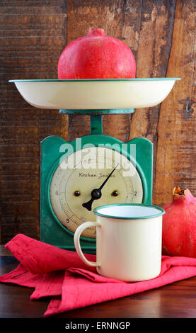 Balance de cuisine vintage et de l'étain tasses et les casseroles sur fond sombre bois usagé. Banque D'Images