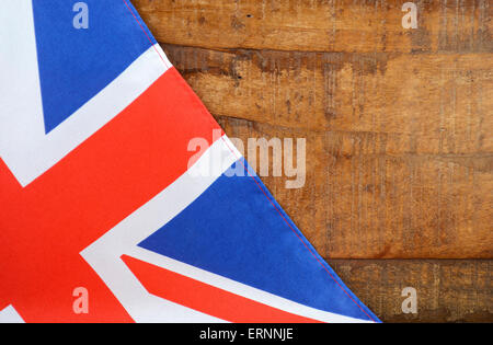Grande Bretagne UK Union Jack Flag contre l'obscurité du bois recyclé en difficulté l'arrière-plan. Banque D'Images