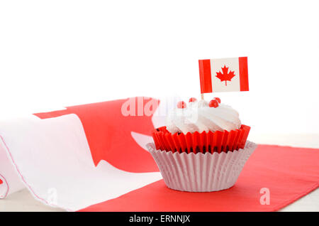 Happy Canada Day celebration cupcake rouge et blanc avec drapeau à feuille d'érable canadienne sur la table en bois blanc. Banque D'Images