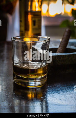 Verre de whisky et de cigare, sur un fond sombre Banque D'Images