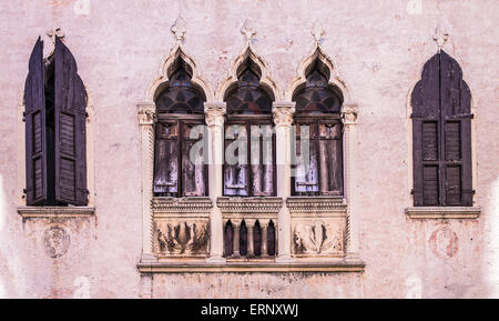 Vieux windows sur un palais médiéval façade dans Vérone, Italie Banque D'Images