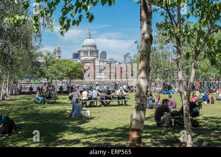 Les gens se détendre dans les jardins de la Tate Modern, la Cathédrale St Paul avec en arrière-plan, Southbank, Londres UK Banque D'Images