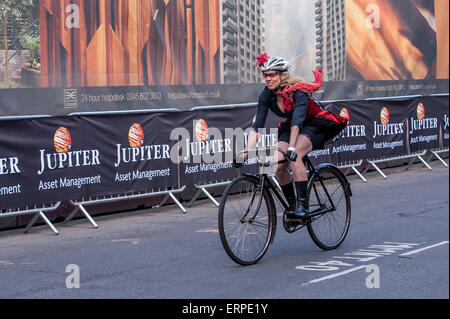 Londres, Royaume-Uni. 6 juin 2015. Une femme en robe de soirée passe par dans le retro Brooks , Critérium que la 9e édition de l'primé Jupiter Londres Nocturne hits les rues de Farringdon. L'événement réunit les meilleures courses critérium de la rapide et technique du circuit de course autour de Smithfield Market, avec un mélange de courses amateur et d'élite pour les coureurs masculins et féminins. Crédit : Stephen Chung / Alamy Live News Banque D'Images