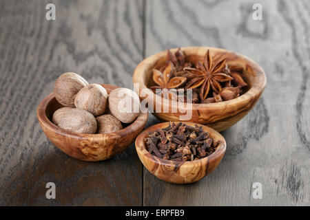 Les étoiles d'anis et de girofle Muscade dans bol d'olive sur la table en chêne, rustique Banque D'Images