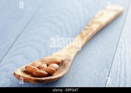 Amandes rôties en cuillère sur la table en bois bleu Banque D'Images