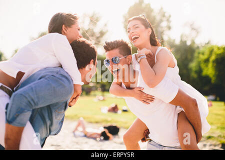 Les jeunes couples s'amusant sur la plage Banque D'Images