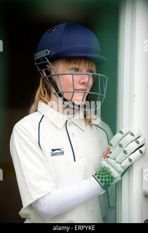 Une fille a l'air d'appréhension en attente de bat à un match de cricket junior filles dans le Wiltshire UK Banque D'Images