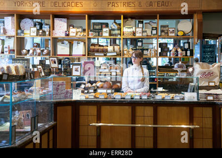 Dame au guichet de Betty's Café et thé, York, Angleterre Banque D'Images