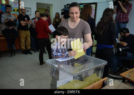 Ankara, Turquie. 7 juin, 2015. L'électeur vote avec un enfant à un bureau de scrutin à Ankara, Turquie, le 7 juin 2015. Les Turcs ont commencé à voter dimanche aux élections législatives pour décider de la forme du prochain gouvernement en Turquie. Credit : Mustafa Kaya/Xinhua/Alamy Live News Banque D'Images