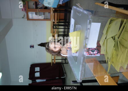 Ankara, Turquie. 7 juin, 2015. Une fille jette sa voix des parents à un bureau de scrutin à Ankara, Turquie, le 7 juin 2015. Les Turcs ont commencé à voter dimanche aux élections législatives pour décider de la forme du prochain gouvernement en Turquie. Credit : Mustafa Kaya/Xinhua/Alamy Live News Banque D'Images