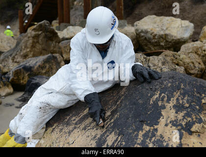 Continuer une équipe de nettoyage pour nettoyer le sable et les roches huileuses pendant les efforts visant à réduire les dommages causés par un pipeline pause à Rufugio State Beach le 6 juin 2015 à Santa Barbara, en Californie. Plus de 105 000 litres de pétrole brut s'est déversé à partir d'un pipeline dans l'une des plus belles sections du littoral de l'état. Banque D'Images