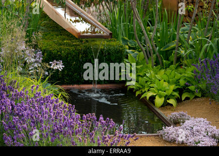 L'eau qui coule sur un petit ruisseau en bois entourés de plantes dans le jardin à la richesse Vestra Hampton Court Flower Show Banque D'Images