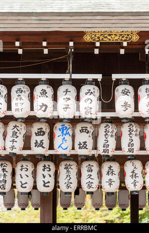 Rangées de chois blancs, lanternes en papier, accrochées au toit de la scène principale, Buden Hall, au sanctuaire Shinto Yasaka de Kyoto, Japon. Banque D'Images