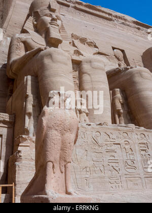 Une statue du dieu Horus comme un pèlerin, aux pieds du colosse de Ramsès II au Temple d'Abou Simbel, Nubie, Egypte Banque D'Images