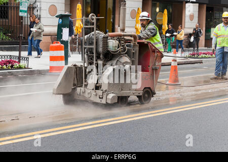 Les travailleurs municipaux de l'aide à pied derrière l'asphalte a vu, Diamant Cut machine - USA Banque D'Images