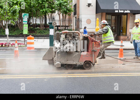 Les travailleurs municipaux de l'aide à pied derrière l'asphalte a vu, Diamant Cut machine - USA Banque D'Images