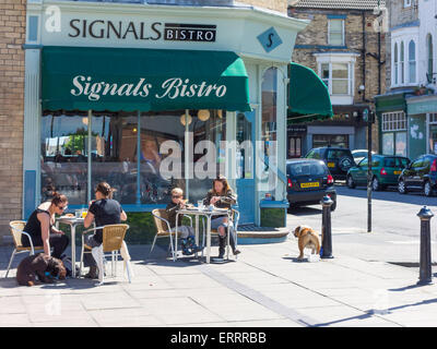 Les clients avec les chiens appréciant leur petit-déjeuner au soleil d'été au Bistro des signaux par la mer Saltburn North Yorkshire Angleterre Banque D'Images