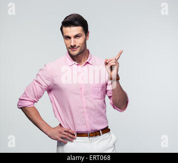 Confident businessman in shirt doigt loin sur fond gris. Looking at camera Banque D'Images