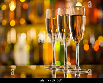 Thème de célébration avec trois verres de champagne. Arrière-plan flou sur les bouteilles Banque D'Images