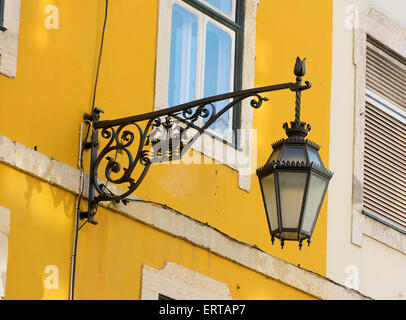 Fer forgé noir traditionnelle lanterne murale sur un mur jaune. Banque D'Images