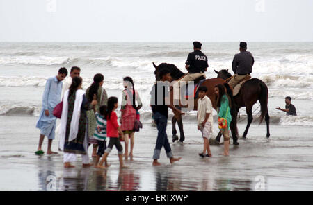 Personnel de police patrouiller sur les chevaux comme interdiction a été imposée à bain en mer sont visiter beach en raison de l'état de la mer alors qu'un cyclone dans la mer d'Oman, dans la région de Karachi le Lundi, Juin 08, 2015. Banque D'Images