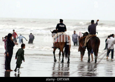 Personnel de police patrouiller sur les chevaux comme interdiction a été imposée à bain en mer sont visiter beach en raison de l'état de la mer alors qu'un cyclone dans la mer d'Oman, dans la région de Karachi le Lundi, Juin 08, 2015. Banque D'Images