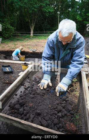 Les archéologues tamisage à sec dans un shaker cadre sur une dig Banque D'Images
