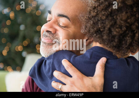 Mixed Race grandfather and grandson hugging at Christmas Banque D'Images