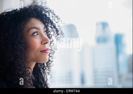 Mixed Race businesswoman looking out window Banque D'Images