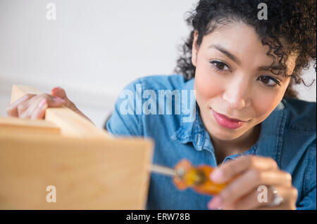 Mixed Race woman montage de meubles Banque D'Images