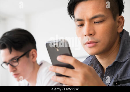 Close up of serious man texting on cell phone Banque D'Images