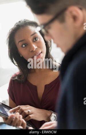 Businesswoman et collègue using digital tablet in office Banque D'Images