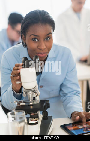 À l'aide scientifique et microscope digital tablet in research laboratory Banque D'Images