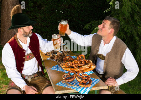 Deux hommes bavarois assis dans un parc et boire de la bière Banque D'Images