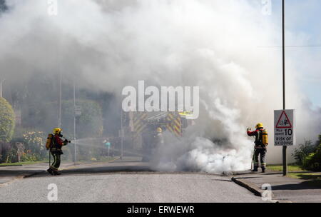 Les pompiers s'attaquer à un véhicule incendie sur une rue résidentielle dans le Derbyshire, Angleterre, RU Banque D'Images