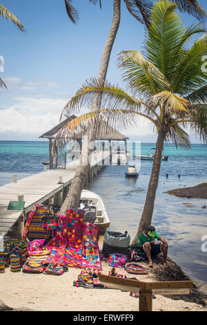 Un vendeur de Béliziens vendre artisanat d'art local et aux touristes sur la plage sur l'île d'Ambergris Caye. Banque D'Images