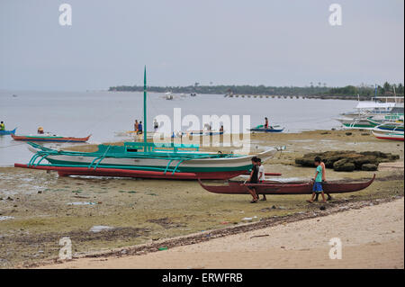 Les jeunes hommes exerçant son bateau de pêche pour l'eau à Panagsama Beach Philippines Moalboal Banque D'Images