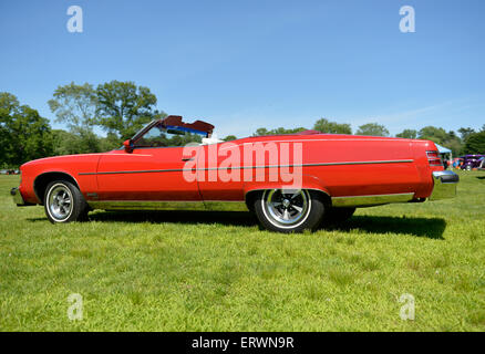 Old Westbury, New York, United States. 7 juin 2015. Une Pontiac Grand Ville rouge 1975 décapotable, vu de côté, côté conducteur, est illustré à la 50e rencontre annuelle de printemps Car Show parrainé par le grand New York Region d' Automobile Club d'Amérique. Plus de 1 000 meubles anciens, classique, et les voitures personnalisées a participé à la populaire Long Island vintage car show qui a eu lieu à l'historique Old Westbury Gardens. Banque D'Images