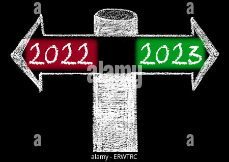 Flèches opposées à l'an 2022 en fonction de l'année 2023. Dessin à la main avec de la craie sur tableau noir. Choix de l'image conceptuelle Banque D'Images