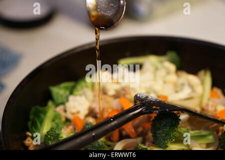 Arroser de sauce sauté frais dans la poêle. Banque D'Images