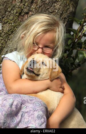 Fille avec Labrador Retriever chiot Banque D'Images