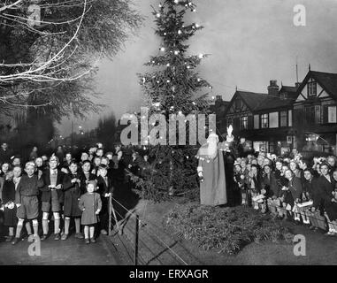 Le Père Noël des enfants de l'école conduit à carol chant autour de l'arbre de Noël du Conseil sur Market Street, Liverpool Hoylake,. 23 Décembre 1953 Banque D'Images