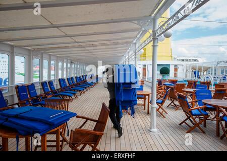 Kiel, Allemagne. 09Th Juin, 2015. Un membre de l'équipe prépare la terrasse avec piscine sur le 'MS Deutschland' à Kiel, Allemagne, 09 juin 2015. Le navire, rendu célèbre par la série télévisée 'Das Traumschiff' (lit. Le navire de rêve), décolle aujourd'hui pour sa dernière croisière voyage sous commandement allemand. Dpa : Crédit photo alliance/Alamy Live News Banque D'Images