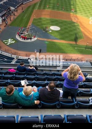 Fans dans les gradins à regarder la pratique au bâton, Yankee Stadium, NEW YORK Banque D'Images
